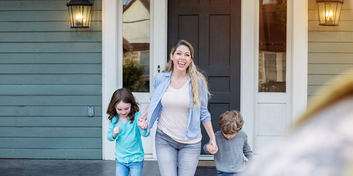 Mother holding her children's hands and smiling.