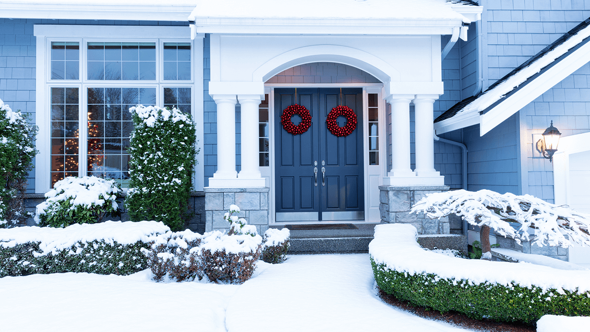 Front of nice home covered in winter snow.